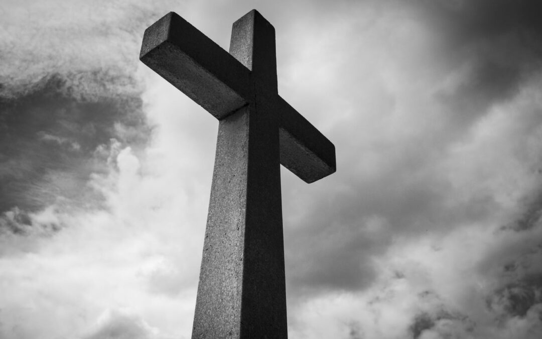 low angle photo of concrete cross under clouds